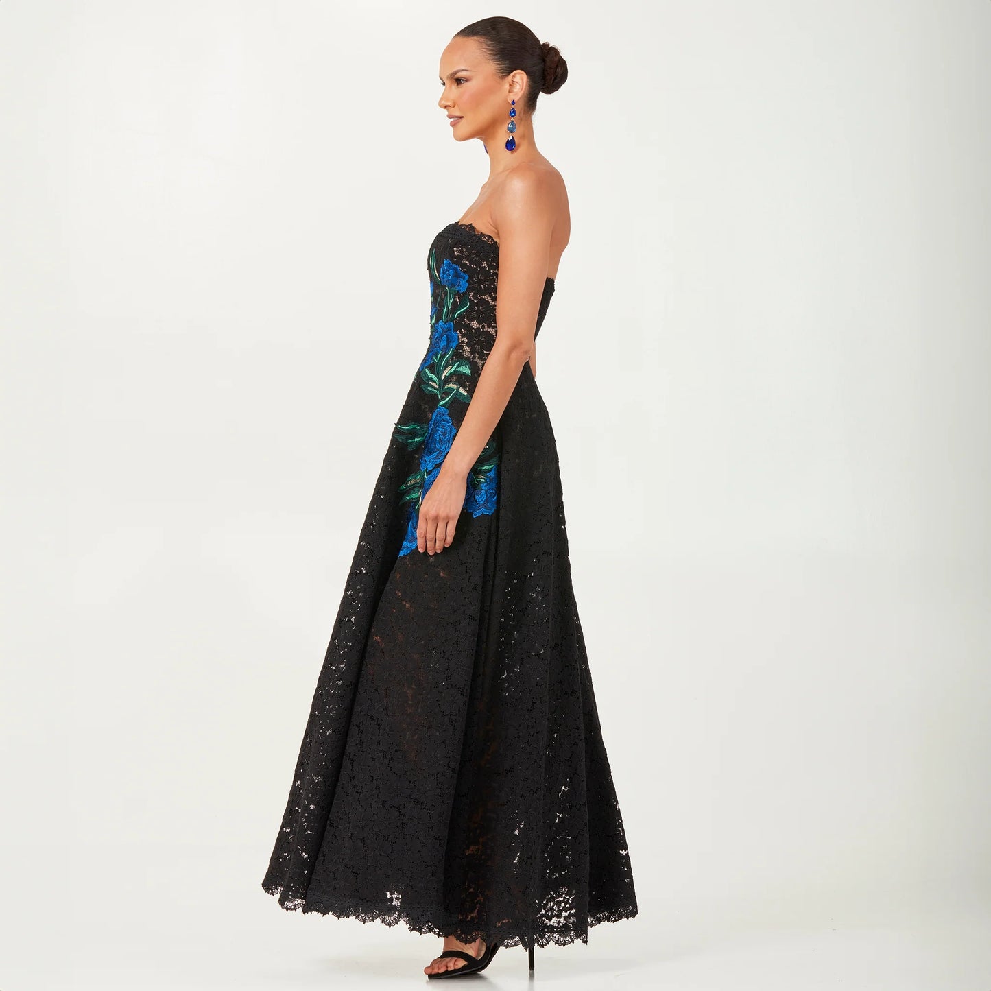 Helsi Patricia DR6252 strapless gown with blue floral embroidery - elegant black lace gown featuring a fit-and-flare silhouette and striking blue floral details.  Side View.