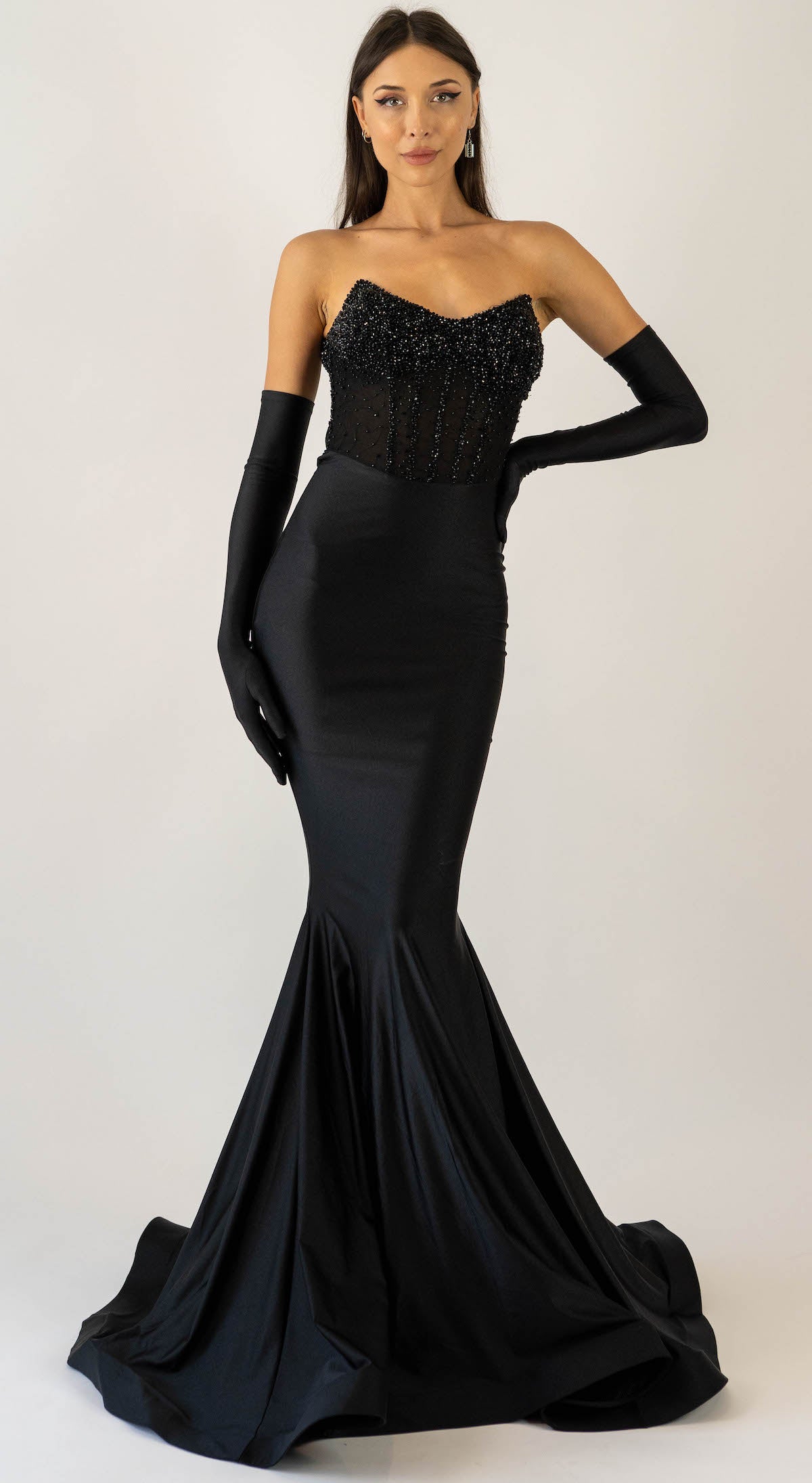 Jessica Angel 2560 Strapless Beaded Gown – A sleek black gown with a fitted silhouette, strapless beaded bodice, and floor-length skirt with a train, perfect for red carpet events.