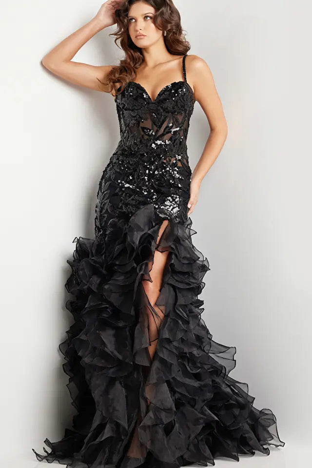 Jovani 38358 Sequin Embellished Mermaid Evening Gown - A glamorous gown featuring an organza ruffle skirt with a slit, sequin embellished bodice with boning and illusion waist, and a mermaid silhouette with a sweetheart neckline. The model is showcasing the dress in black.