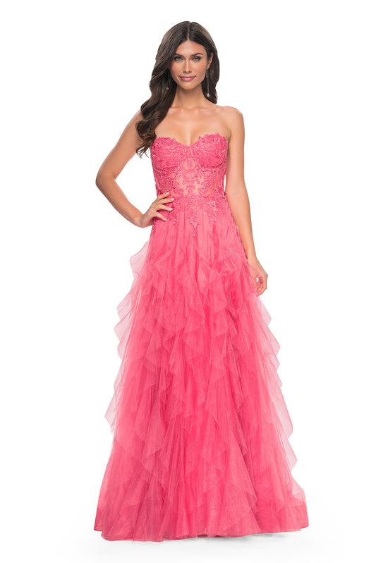 La Femme 32286 Illusion Lace Bustier A-Line Prom Gown - A captivating A-line gown featuring a ruffle tulle skirt, high slit, and illusion lace bustier bodice for a glamorous and sophisticated prom look.  The model is wearing the dress in the color coral.