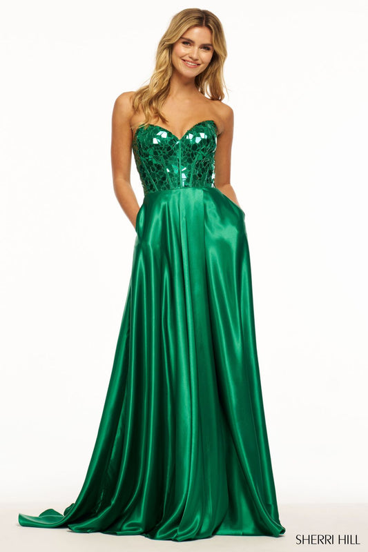 Sherri Hill 56041 Strapless Charmeuse Gown with Cut Glass Corset Bodice - A stunning strapless gown featuring a cut glass corset bodice, sweetheart neckline, and high skirt slit. Perfect for making a statement at prom. The model is wearing the dress in the color emerald.