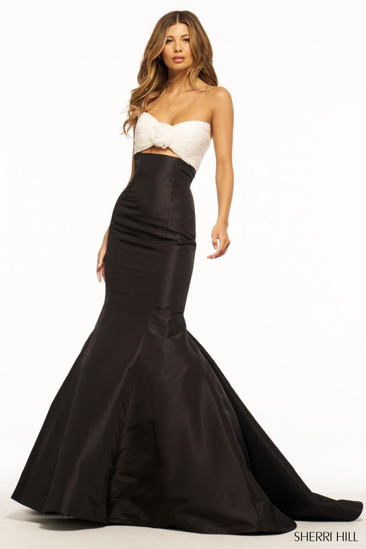 A mesmerizing strapless taffeta mermaid prom gown with a ruched neckline, keyhole, and intricate flower detail on the bodice. Perfect for prom or evening events.