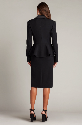 A woman wearing a long-sleeved textured crepe evening dress with a tuxedo collar, perfect for elegant evening occasions.