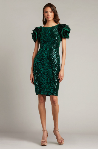 A woman wearing a close-fitting velvet sheath dress with oversized rosette sleeves and intricate paillette embroidery, perfect for elegant evening occasions.